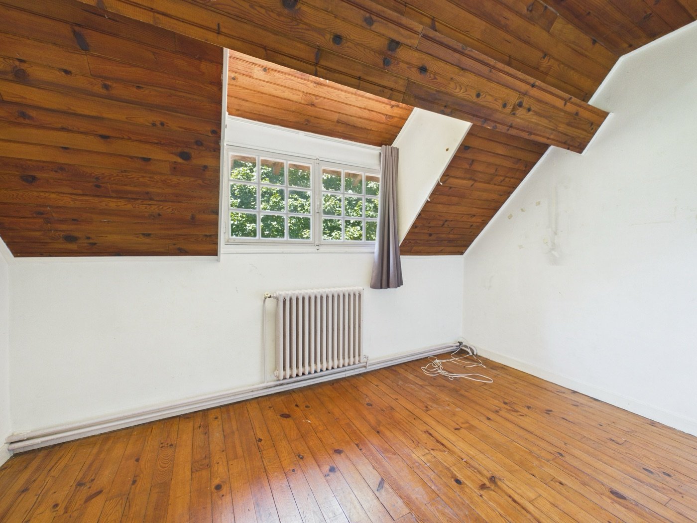 Chambre sous comble du lot 1, poutres et plafond bois apparents, état actuel
